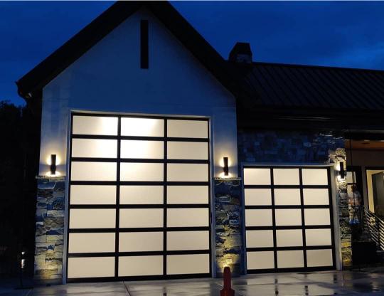 Front view of illuminated glass paneled garage doors